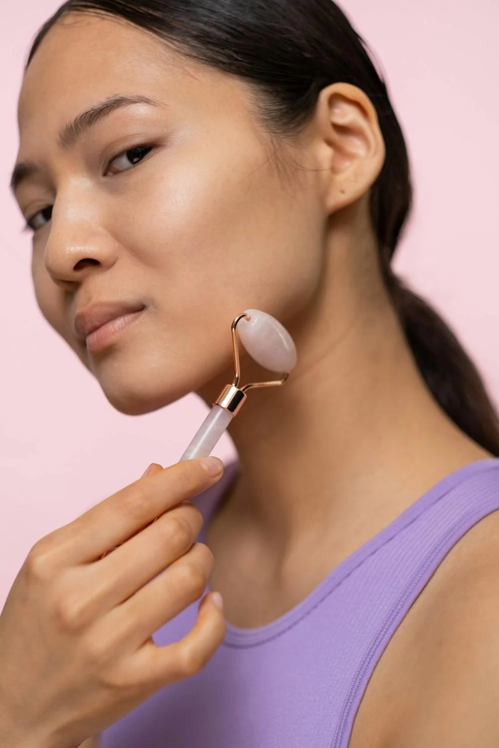 Woman massaging face with roller.
